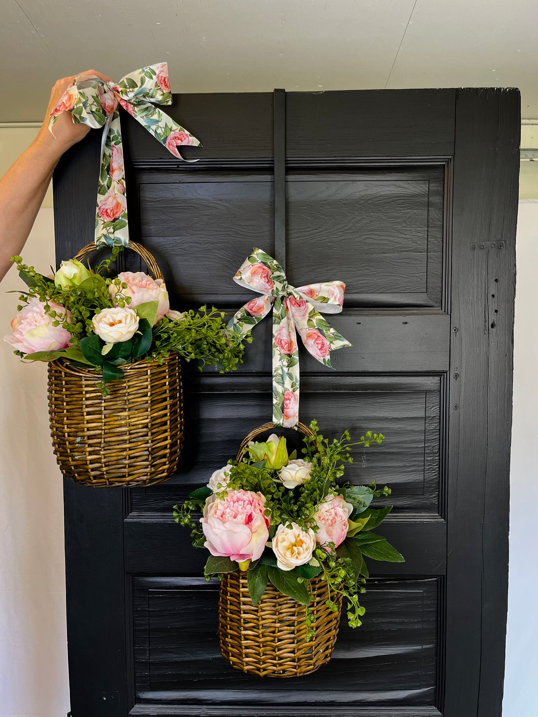 Decorative flower basket with a floral bow on a wooden door
