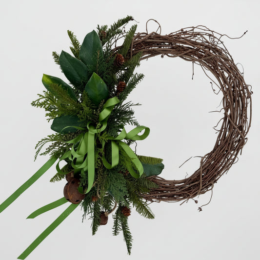 Decorative wreath with greenery and ribbons on a light gray background