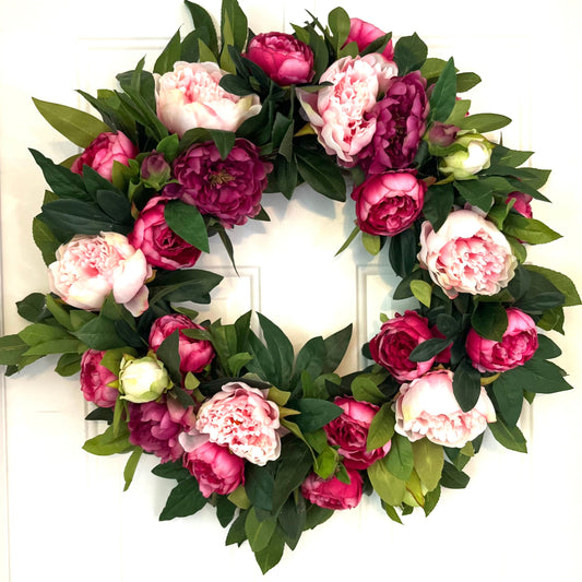Floral wreath with pink and purple flowers on a white door