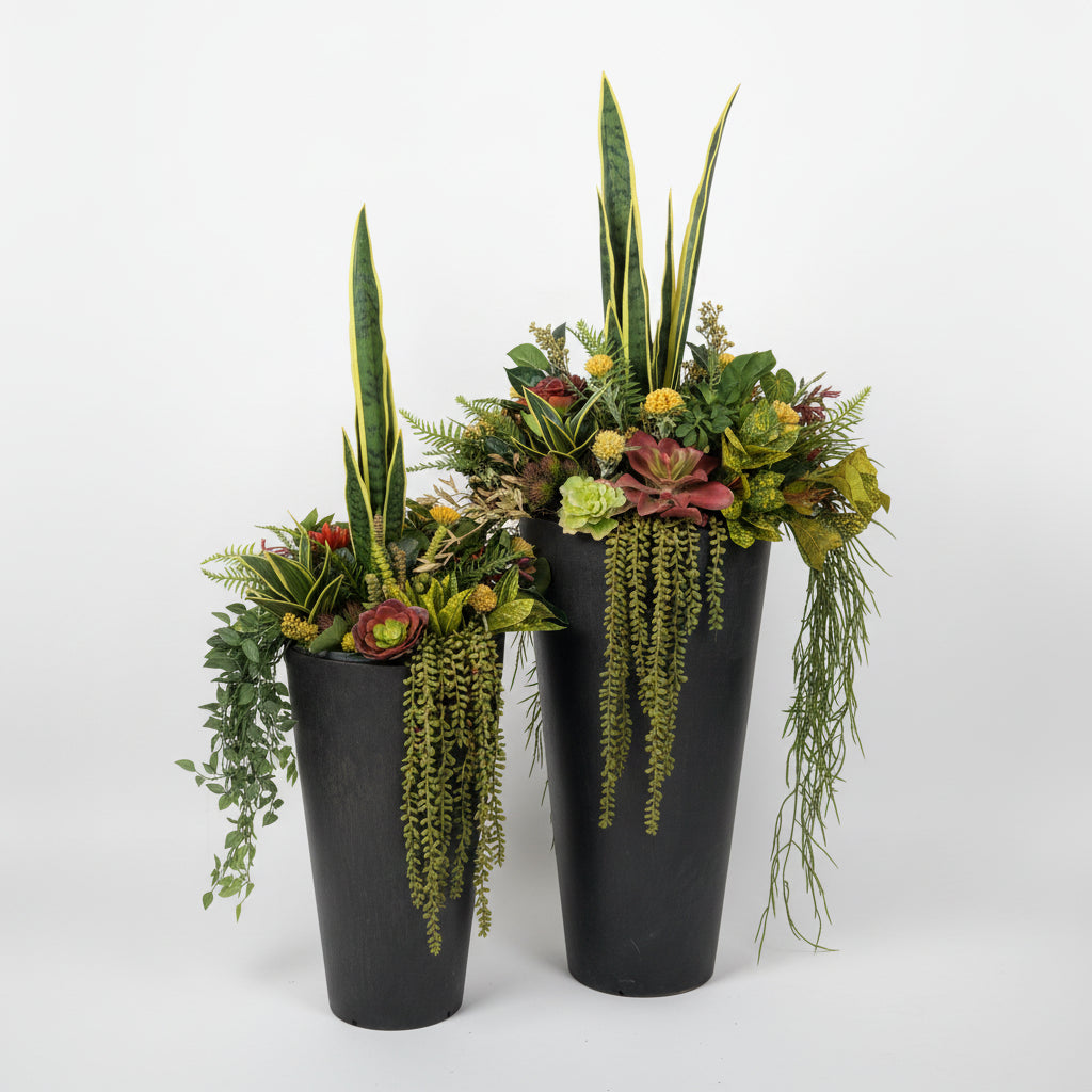 Two artificial planter inserts with a variety of faux succulents and plants in shades of yellow, red, and green, placed in pots by a door.