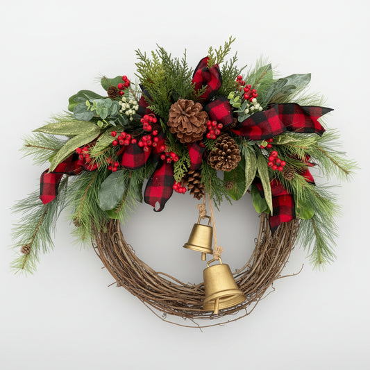 Christmas wreath with greenery, red berries, plaid ribbon, pinecones, and gold bells on a gray background.