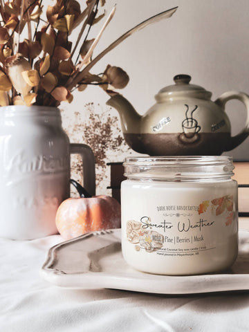 Sweater Weather soy candle on a white tray with a vintage teapot