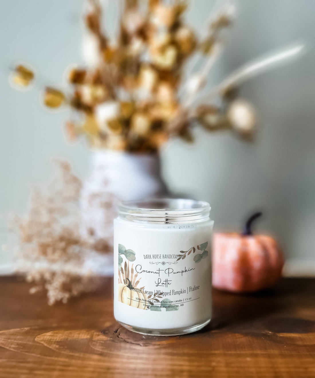 Pumpkin latte scented soy candle styled with a teapot and mini pumpkin