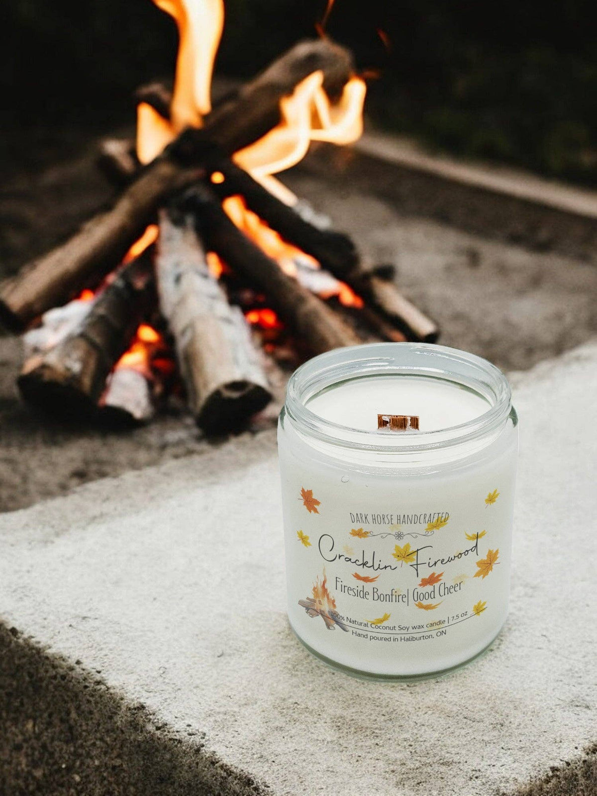 Crackling Firewood wood wick candle glowing in front of a campfire